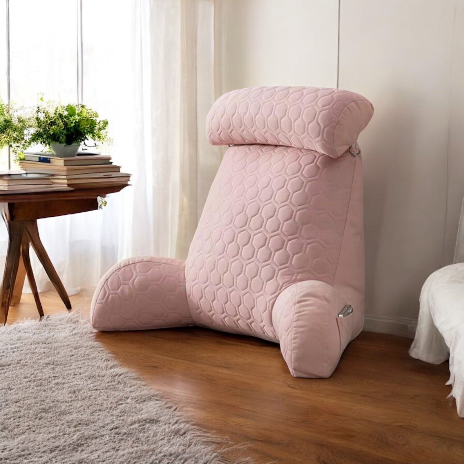 Ergonomic cushion on a wooden floor next to a window with sunlight coming in to the room.